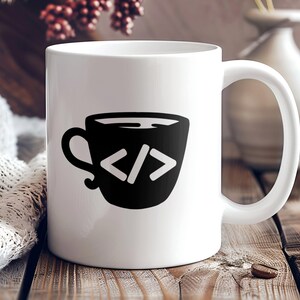 May include: White ceramic coffee mug with a black and white illustration of a coffee cup with the code "</>" inside.