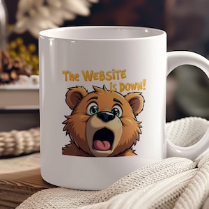 May include: White ceramic coffee mug with a cartoon bear with a surprised expression. The text "The Website Is Down!" is printed on the mug.