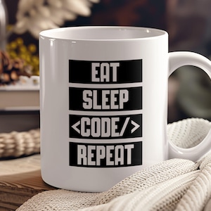May include: White ceramic coffee mug with black text that reads "Eat Sleep <CODE/> Repeat".