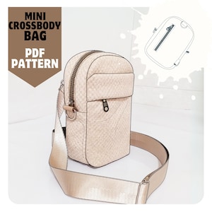 May include: A beige mini crossbody bag with a zipper closure and a long adjustable strap. The bag has a small pocket on the front and a zippered pocket on the back. The bag is made of a textured fabric and has a gold-colored zipper and hardware. The image also includes a line drawing of the bag.
