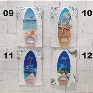 May include: Four surfboard-shaped bottle openers with beach-themed designs. Each opener has a different ocean scene, with the names "Jesse & Clark" and the date "09 August 2025" printed on them. The openers are displayed on white cards.