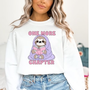 A bookish sweatshirt png mockup of the One More Chapter design.