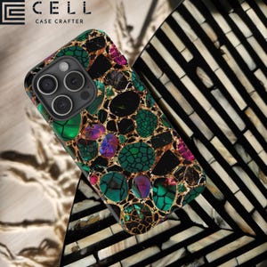 May include: A black phone case with a green, gold, and purple abstract pattern. The case has a raised camera bump and the text "CELL CASE CRAFTERS" is printed on the top.