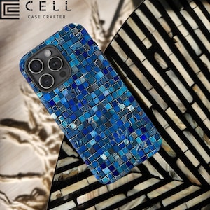 Op de afbeelding: Een blauwe telefoonhoes met een mozaïekpatroon. De hoes is gemaakt van hard plastic en heeft een verhoogde rand rond de camera lens om deze te beschermen tegen krassen. De hoes is ontworpen om te passen op een iPhone 13 Pro Max.