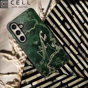 May include: A green phone case with a gold mantis and floral design. The case has a raised camera bump with three lenses. The text "CELL CASE CRAFTERS" is printed on the case.