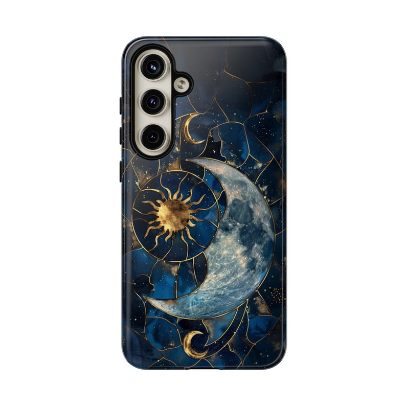 May include: A phone case with a blue and gold design featuring a crescent moon and sun. The design is set against a dark blue background with gold accents.