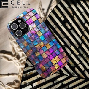 May include: A black iPhone case with a mosaic pattern of iridescent blue, purple, and gold squares. The case is on a background of black and white striped material.