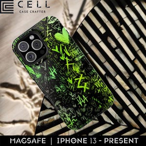 May include: Black iPhone case with a neon green graffiti design, including hearts and symbols. The case is for iPhone 13 and newer models and is MagSafe compatible. The case is made by Cell Case Crafter.