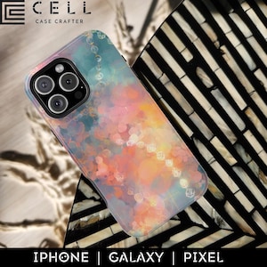 Puede incluir: Una funda para smartphone con un diseño abstracto colorido. La funda presenta una mezcla de tonos rosa, naranja y turquesa con un patrón de cadena decorativa. La marca "E CELL CASE CRAFTER" es visible en la parte superior. La parte inferior de la imagen muestra las palabras "IPHONE | GALAXY | PIXEL".
