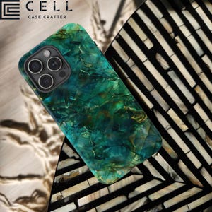 May include: A green and blue marble phone case with a textured surface. The case is designed for an iPhone with a triple camera lens. The case is on a black and white patterned surface. The text "CELL CASE CRAFTERS" is visible in the top left corner of the image.