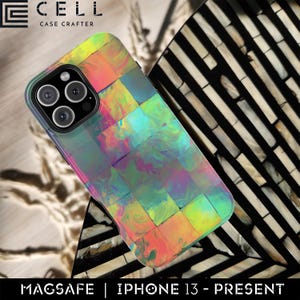 May include: A colorful iPhone case with a mosaic-like design in shades of green, pink, and yellow. The case has a glossy finish and features the text "MAGSAFE | IPHONE 13 - PRESENT". The case is designed to fit an iPhone 13 or newer model.