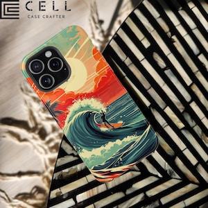 May include: A phone case with a retro-style illustration of a surfer riding a wave against a sunset background. The case features a blue, green, and yellow color scheme with a red and orange sunset. The text "CELL CASE CRAFTERS" is printed on the top of the case.