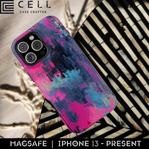 May include: A smartphone case with a colorful abstract design in shades of pink, blue, and black. The case is designed for iPhone 13 and newer models and is MagSafe compatible. The brand name "CELL CASE CRAFTER" is visible at the top.