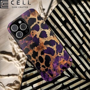 May include: A black phone case with a leopard print design in shades of purple, brown, and gold. The case has a raised camera bump and the text "CELL CASE CRAFTERS" is printed on the top.