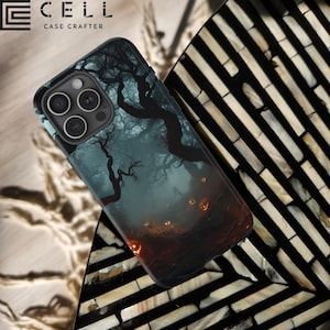 May include: A black phone case with a spooky forest scene featuring a foggy path, dark trees, and glowing jack-o'-lanterns. The case has a raised camera bump and the text "CELL CASE CRAFTERS" is printed on the top.