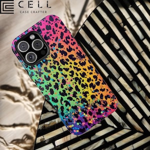 May include: A colorful phone case with a leopard print design. The case features a vibrant mix of pink, yellow, green, and blue hues, with black spots. The brand name "E CELL CASE CRAFTER" is printed at the top.