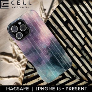 May include: A smartphone case with a colorful design. The case features a pattern of purple, blue, and white circles and lines. The case has a black camera module and the text "MAGSAFE | IPHONE 13 - PRESENT". The case is made by CELL CASE CRAFTER.