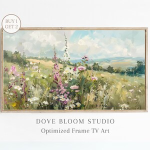 Pode incluir: Uma pintura emoldurada que representa um campo de flores silvestres em tons de rosa, branco e verde. O campo está situado em um fundo de colinas onduladas e um céu azul com nuvens brancas. A pintura é intitulada "Dove Bloom Studio" e "Optimized Frame TV Art".