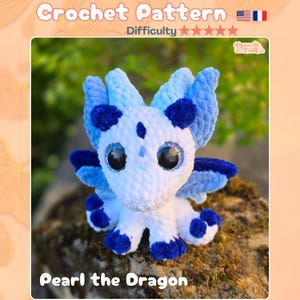Peut inclure: Un modèle de crochet pour un dragon en peluche nommé Pearl, avec un corps en fil blanc et bleu clair, des accents bleu foncé, de grands yeux de sécurité noirs à paillettes bleues et un aspect texturé. Le texte indique Crochet Pattern et Pearl the Dragon.