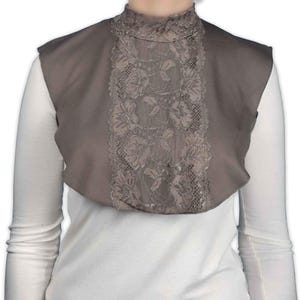 May include: A gray mock neck shirt with a lace overlay. The lace is a delicate floral pattern.