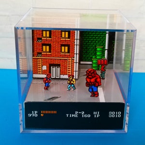May include: A diorama of a video game scene featuring a red brick building, a green pipe, and three pixelated characters. The characters are fighting a large red monster. The diorama includes a video game screen with the text "1P 970", "P-2 TIME 160", "HI 1P 3010", and "3010".
