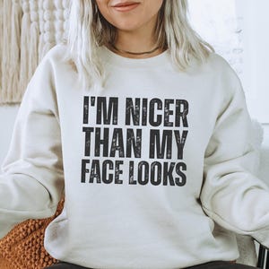 Pu&ograve; includere: Felpa color crema con la scritta "I'M NICER THAN MY FACE LOOKS" in lettere nere sbiadite. Uno stile casual, adatto all'uso quotidiano.