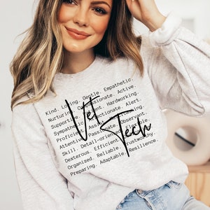 Könnte beinhalten: Ein grauer Pullover mit schwarzem Text, der lautet "Kind. Loving. Gentle. Empathetic. Nurturing. Compassionate. Active. Supportive. Patient. Hardworking. Sympathetic. Affectionate. Alert. Proficient. Assist. Multitasking. Attentive. Passionate. Observant. Skill. Detail-oriented. Flexible. Dexterous. Efficient.  Reliable. Trustworthy. Preparing. Adaptable. Resilience."