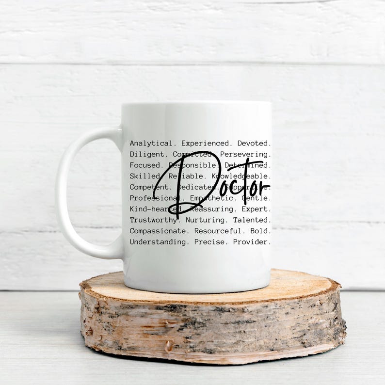 May include: White ceramic mug with a black handle. The mug has a black text design that reads "Analytical. Experienced. Devoted. Diligent. Committed. Persevering. Focused. Responsible. Determined. Skilled. Reliable. Knowledgeable. Competent. Dedicate. Doctor. Professional. Empathetic. Gentle. Kind-hearted. Reassuring. Expert. Trustworthy. Nurturing. Talented. Compassionate. Resourceful. Bold. Understanding. Precise. Provider."