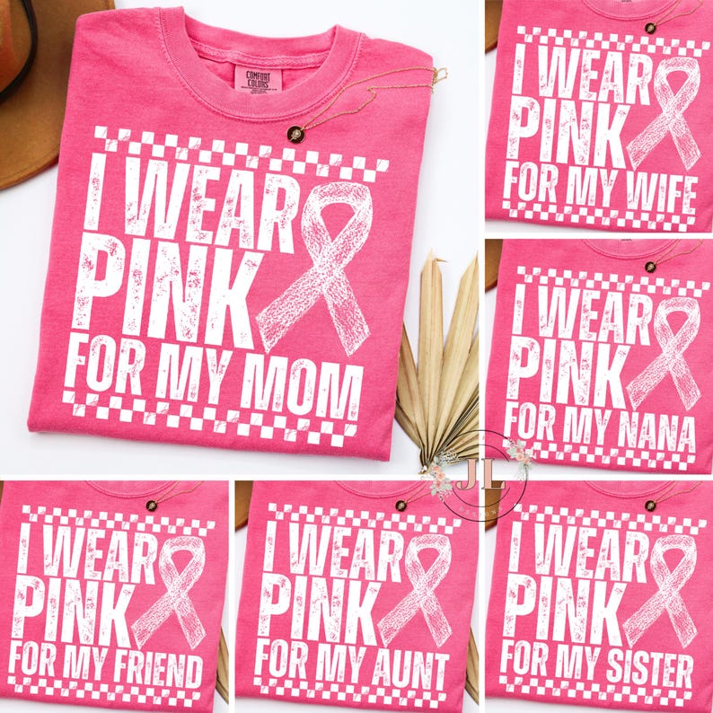 May include: Pink t-shirts with white text and a pink ribbon design. The shirts say "I WEAR PINK" followed by "FOR MY MOM", "FOR MY WIFE", "FOR MY NANA", "FOR MY FRIEND", "FOR MY AUNT", and "FOR MY SISTER".