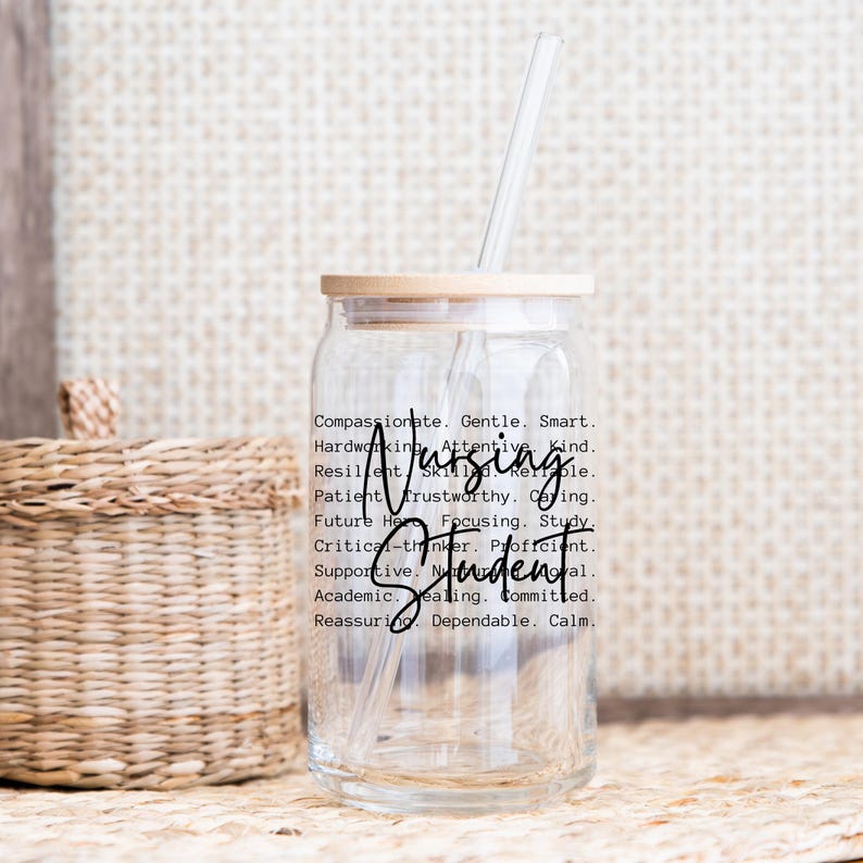 May include: A clear glass water bottle with a bamboo lid and a straw. The bottle has a sticker with the words "Nursing Student" and a list of positive attributes.
