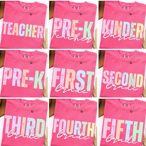 K&ouml;nnte beinhalten: Neun pinkfarbene T-Shirts mit Text zum Thema Schule. Die Shirts zeigen die W&ouml;rter "Teacher", "Pre-K", "Kindergarten", "First Grade", "Second Grade", "Third Grade", "Fourth Grade" und "Fifth Grade" in Pastellfarben. Jedes Shirt hat einen kleinen Knopf.