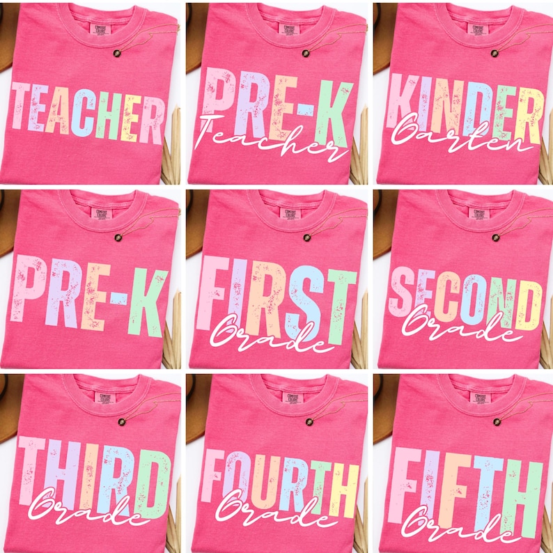 K&ouml;nnte beinhalten: Neun pinkfarbene T-Shirts mit Text zum Thema Schule. Die Shirts zeigen die W&ouml;rter "Teacher", "Pre-K", "Kindergarten", "First Grade", "Second Grade", "Third Grade", "Fourth Grade" und "Fifth Grade" in Pastellfarben. Jedes Shirt hat einen kleinen Knopf.