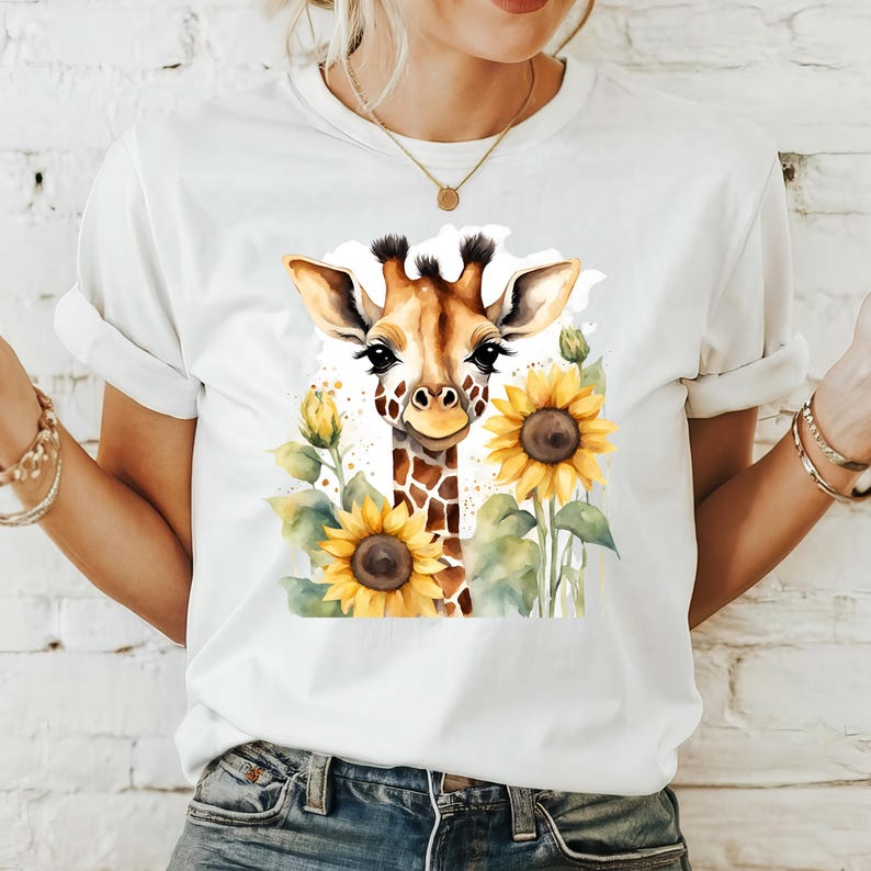May include: White t-shirt featuring a watercolour illustration of a giraffe with sunflowers. The giraffe is brown and has a long neck. The sunflowers are yellow with brown centres.
