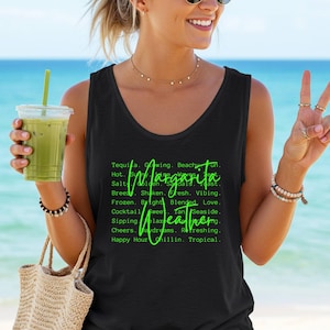 May include: Black tank top with the words "Margarita Weather" in green script. The tank top is worn by a person holding a green drink in a clear plastic cup. The background is a beach scene with blue water and sky.