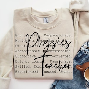 以下が含まれることがあります： ベージュのトレーナーに、「Physics Teacher」という文字が黒で書かれています。この言葉は、熱心、思いやり、愛情深く、励みになる、親切、規律正しい、計画的、賢い、近づきやすい、理解力がある、支えになる、詳細志向、明るい、論理的、情熱的、熟練した、エキサイティング、経験豊富、集中力があり、鋭いなど、ポジティブな形容詞のリストによって定義されています。