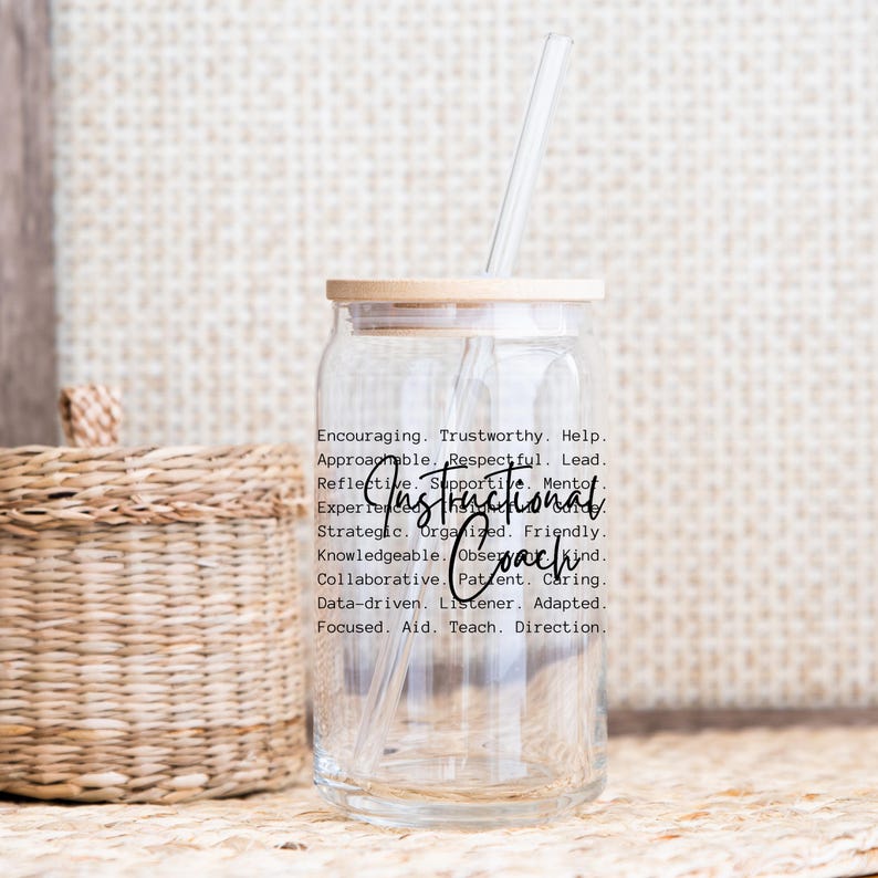 May include: A clear glass tumbler with a bamboo lid and a straw. The tumbler has the words "Instructional Coach" in a script font, along with a list of related words. A woven basket is in the background.