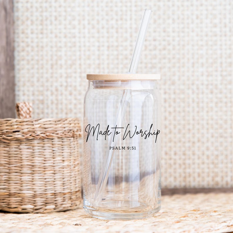 May include: Clear glass can-shaped tumbler with a bamboo lid and a clear straw. The words "Made to Worship" and "Psalm 9:51" are printed in black script on the front. A woven basket is in the background.