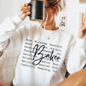 Puede incluir: Una sudadera blanca de manga larga con texto en negro que dice: Warm. Wholesome. Heartfelt. Sweet. Delicious. Artistic. Handcrafted. Homemade. Joy. Therapeutic. Precise. Satisfying. Indulgent. Fun. Delightful. Creative. Busy. Meticulous. Detailed. Soft. Comforting. Rewarding. Pro. Baker.