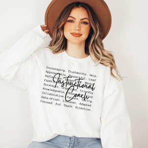May include: White long-sleeve sweatshirt with the words "Instructional Coach" in a handwritten font. Surrounding the text are words like "Encouraging," "Trustworthy," and "Supportive."