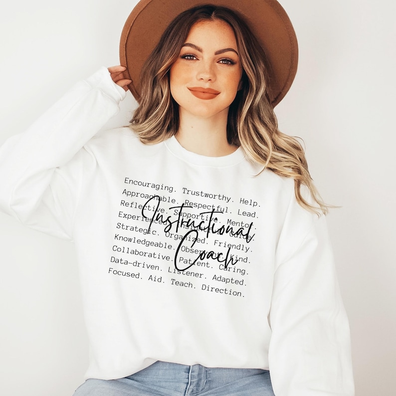 May include: White long-sleeve sweatshirt with the words "Instructional Coach" in a handwritten font. Surrounding the text are words like "Encouraging," "Trustworthy," and "Supportive."