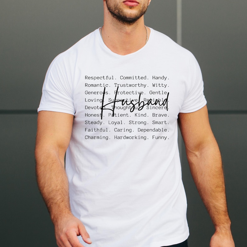May include: A white t-shirt with the word "Husband" in a handwritten font. The shirt also features a list of positive attributes such as "Respectful," "Committed," and "Funny" in a black, sans-serif font.