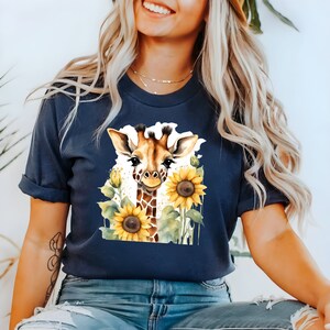 May include: A navy blue t-shirt featuring a watercolour illustration of a giraffe with sunflowers. The giraffe is looking at the viewer and has a friendly expression.