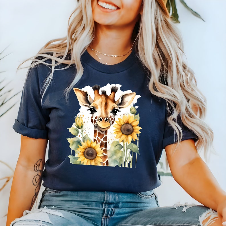 May include: A navy blue t-shirt featuring a watercolour illustration of a giraffe with sunflowers. The giraffe is looking at the viewer and has a friendly expression.