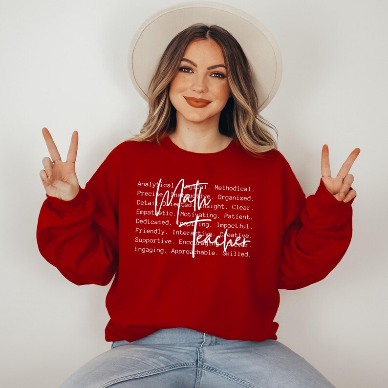 May include: A red sweatshirt with white text that reads "Analytical, Methodical, Precise, Detail-Oriented, Insight, Clear, Empathetic, Motivating, Patient, Dedicated, Impactful, Friendly, Interactive, Creative, Supportive, Engaging, Approachable, Skilled. Math Teacher."