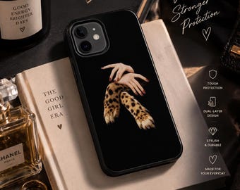 May include: A black smartphone case featuring a graphic print of two hands with dark red nail polish resting on a leopard print sleeve. The case has a dual-camera cutout at the top left corner and a smooth, matte finish on the back surface.