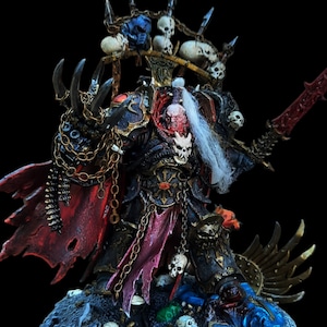 May include: A black and red painted miniature figure of a warrior with a skull helmet, holding a sword and wearing a cape. The figure is standing on a base with skulls and other details.