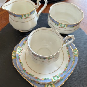 May include: A vintage tea set with a blue and white floral pattern. The set includes a teapot, a sugar bowl, a cup and saucer.