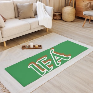 May include: A green yoga mat with the name "LEA" written in white and brown letters.