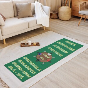 May include: A green and yellow runner rug with the words "Make It", "Oldumare", "Alafogun", "Ajejogun", "Orunmila", "Barapetu", "Eleri-Ipin", "Ela-Ifa" and a circular graphic with the words "Orun", "Aye" in the center.