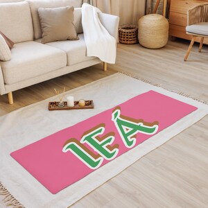 May include: A pink yoga mat with the name "LEA" written in green and brown letters.